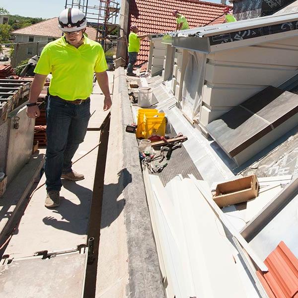 Construction workers install new tile roof on Rankin Hall