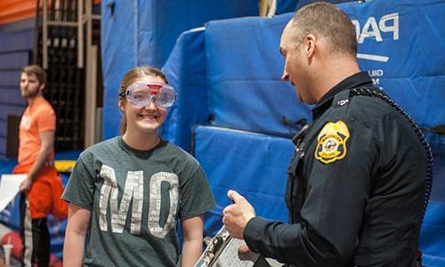 戴着醉醺醺的护目镜的学生跟警察说话